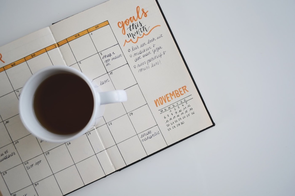 Agenda abierta con una taza de café