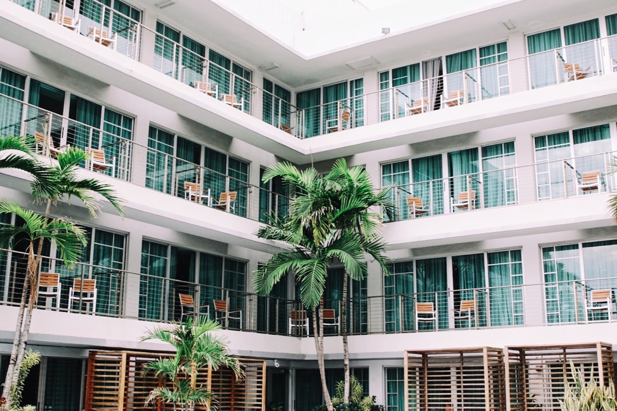 Fachada de un hotel con balcones y palmeras