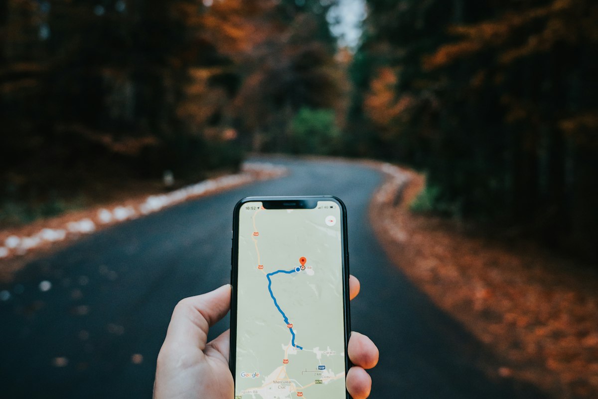 Mano sosteniendo un celular con un mapa de navegación